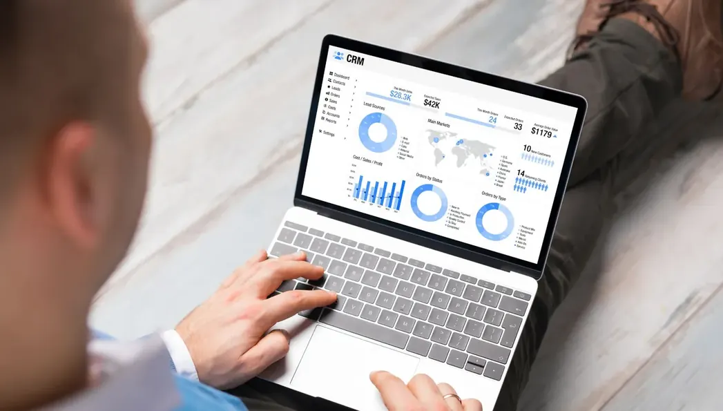 Mãos operando notebook que exibe gráficos de desempenho